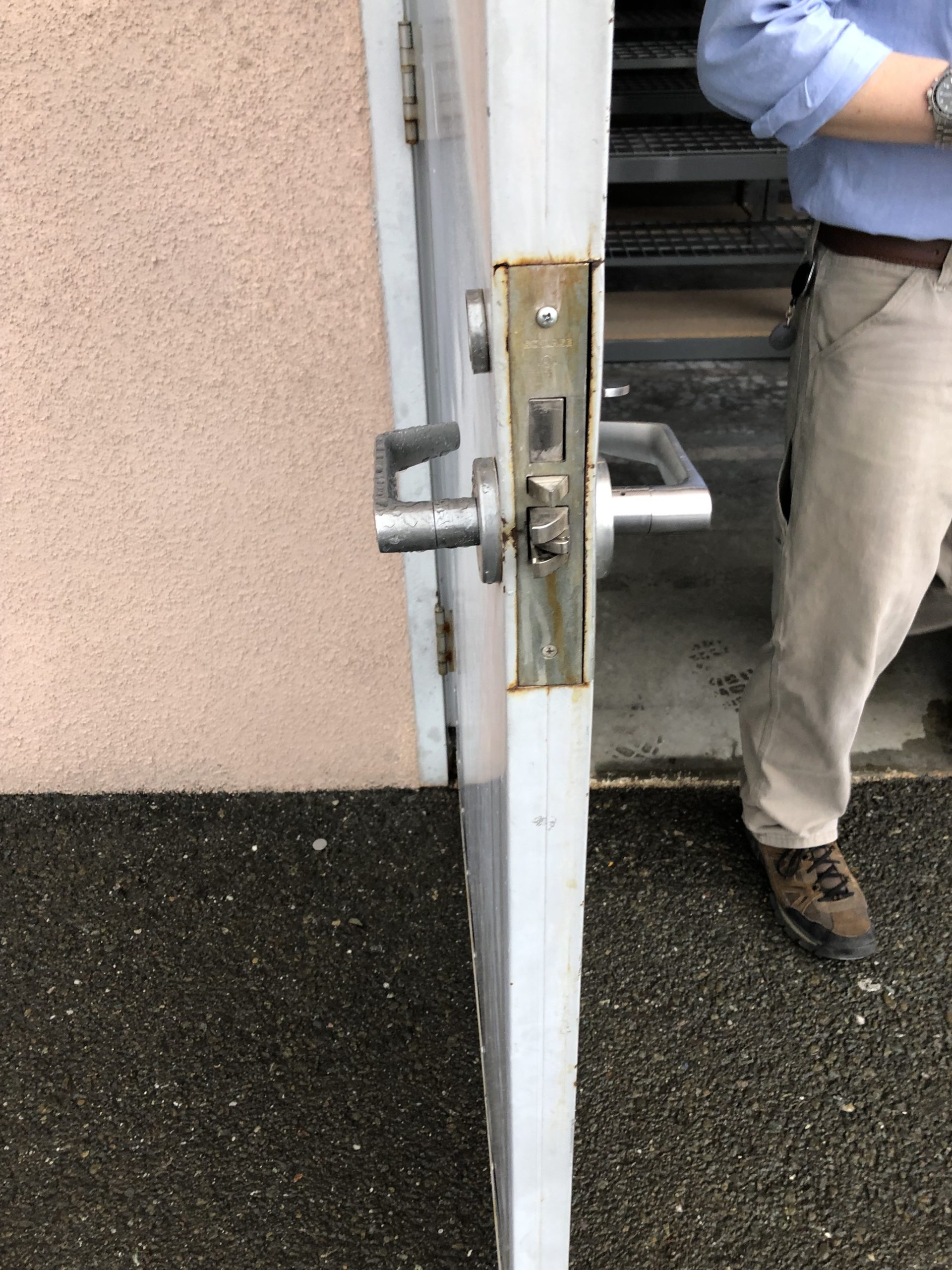 commercial lock being replaced on exterior door behind the building